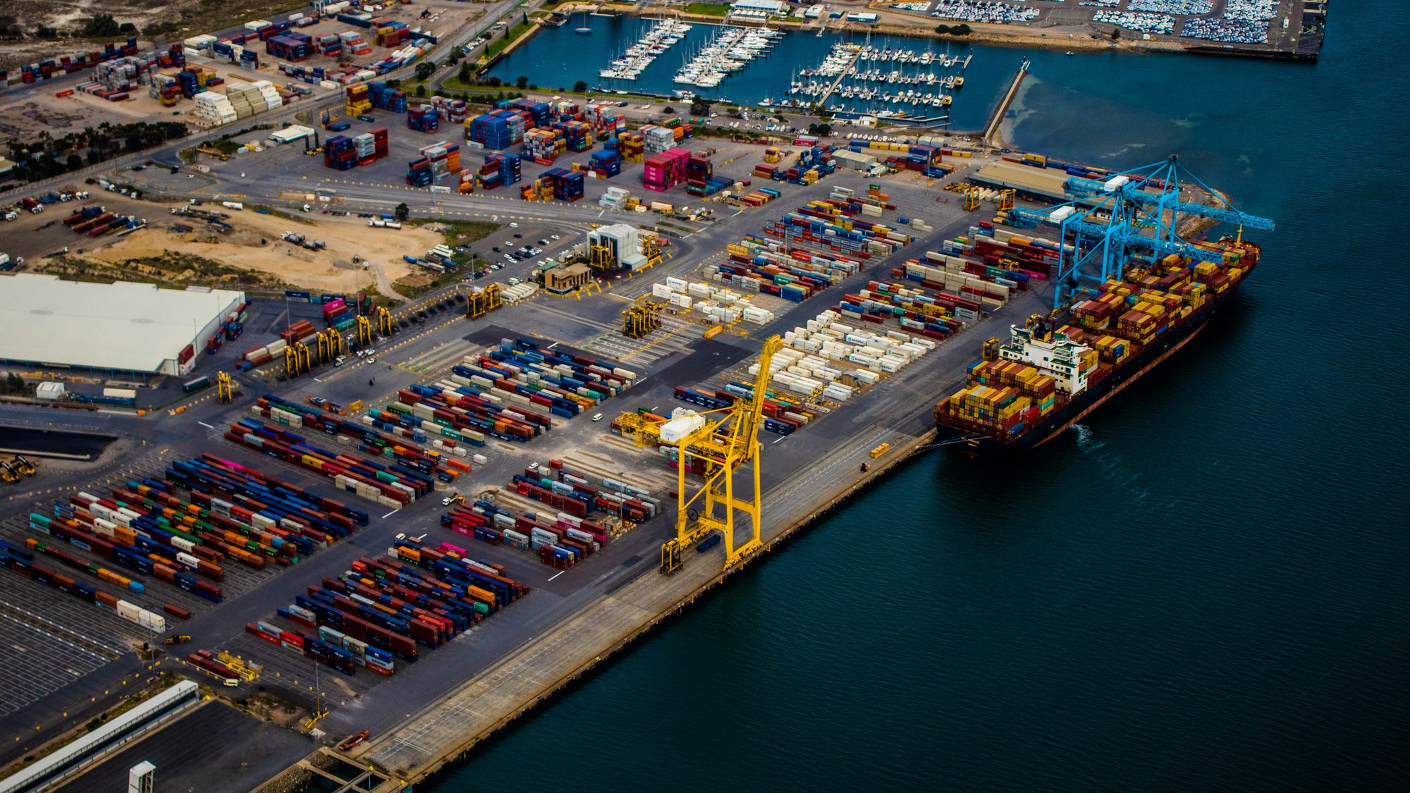 Container terminal seen from above: cranes, ships, and thousands of moving dependencies